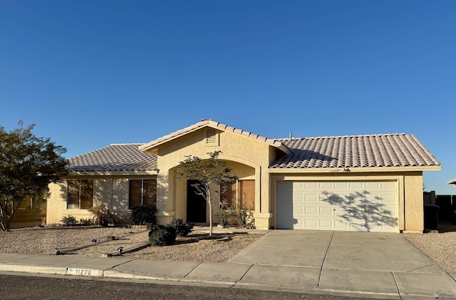 11278 E 24th Pl, Yuma, AZ 85367 - mediterranean / spanish house with an attached garage, stucco siding, a tiled roof, and concrete driveway