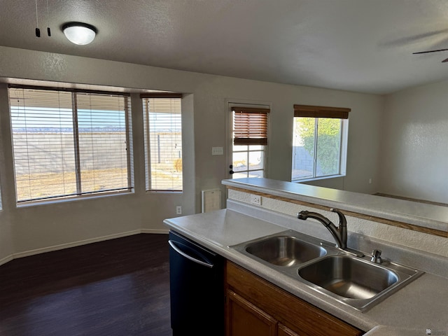 11278 E 24th Pl, Yuma, AZ 85367 - kitchen featuring brown cabinetry, dishwasher, a sink, baseboards, and dark wood-type flooring