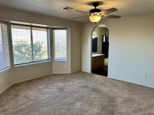 11278 E 24th Pl, Yuma, AZ 85367 - spare room featuring arched walkways, a ceiling fan, dark carpet, and visible vents