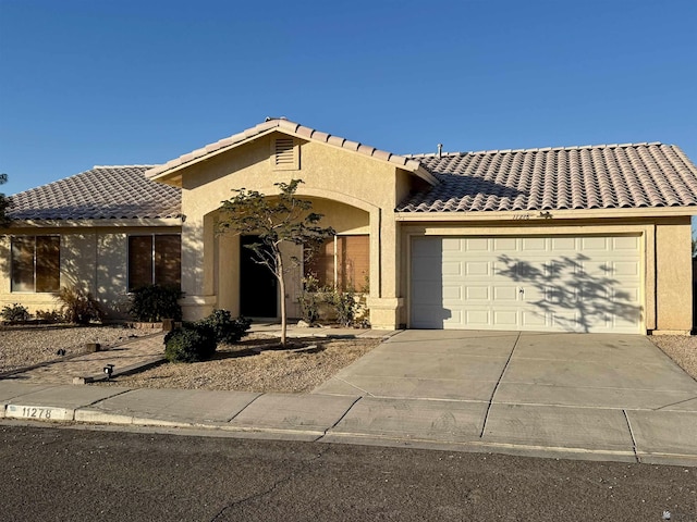 11278 E 24th Pl, Yuma, AZ 85367 - view of front facade with a garage, stucco siding, a tiled roof, and driveway