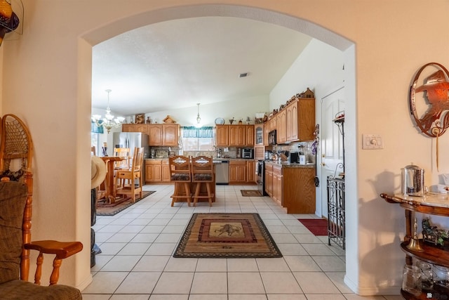 14530 E 55th St, Yuma, AZ 85367 - kitchen with a chandelier, tasteful backsplash, arched walkways, light tile patterned floors, and stainless steel appliances