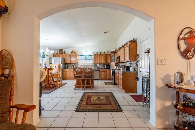 14530 E 55th St, Yuma, AZ 85367 - kitchen with a chandelier, tasteful backsplash, arched walkways, light tile patterned floors, and stainless steel appliances
