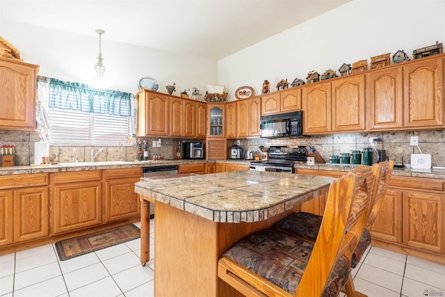 14530 E 55th St, Yuma, AZ 85367 - kitchen featuring black microwave, stainless steel electric range oven, a kitchen bar, and light tile patterned flooring