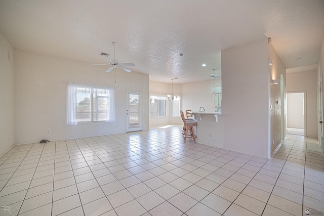 13779 E 54th Dr, Yuma, AZ 85367 - unfurnished living room with a textured ceiling, visible vents, and ceiling fan with notable chandelier