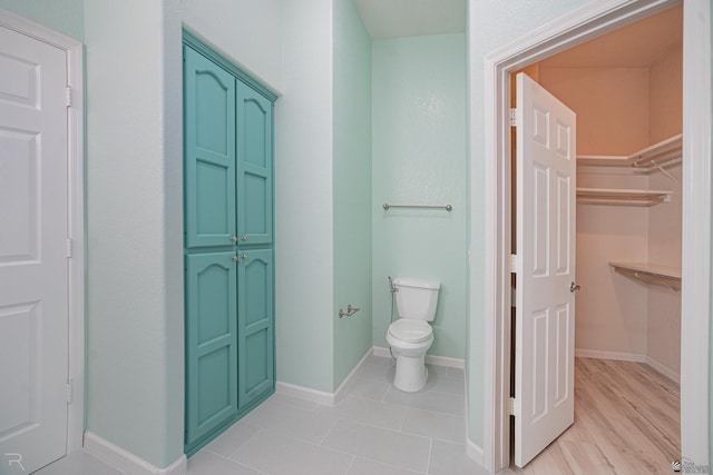 13779 E 54th Dr, Yuma, AZ 85367 - full bathroom featuring a walk in closet, baseboards, toilet, and tile patterned flooring