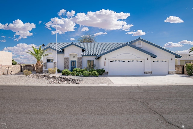 13779 E 54th Dr, Yuma, AZ 85367 - view of front facade featuring a garage, fence, stone siding, and stucco siding
