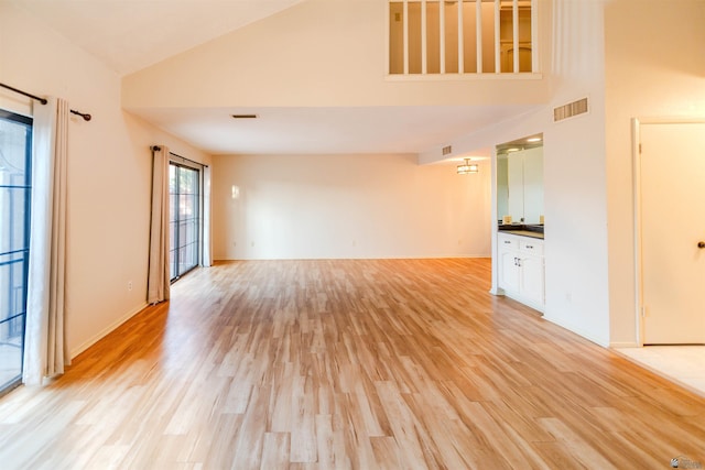 12402 E Via Estrella, Yuma, AZ 85367 - unfurnished living room featuring high vaulted ceiling, light wood-style floors, and baseboards