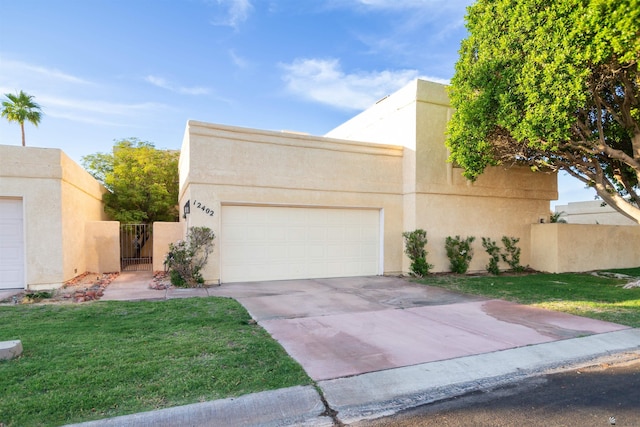 12402 E Via Estrella, Yuma, AZ 85367 - adobe home with a garage, concrete driveway, stucco siding, and a gate