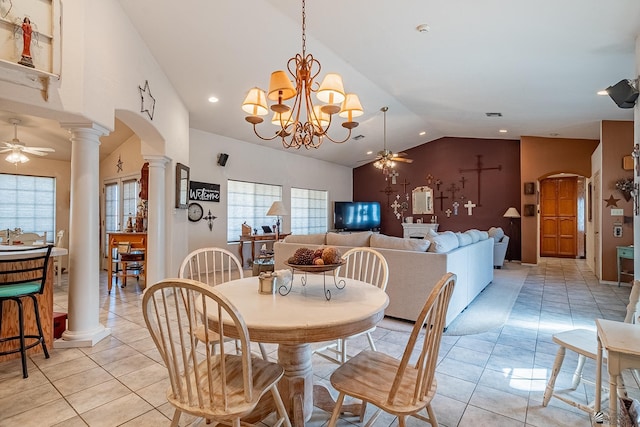 dining room with ceiling fan with notable chandelier, ornate columns, vaulted ceiling, and light tile patterned flooring