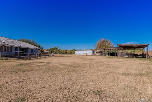 view of yard featuring a rural view and an outdoor structure