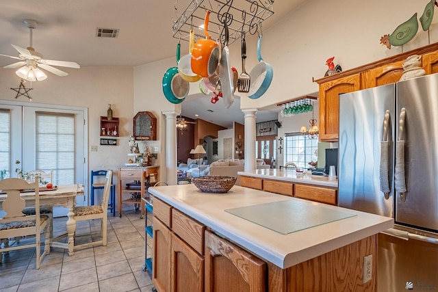 kitchen featuring stainless steel fridge, black electric stovetop, decorative columns, ceiling fan, and light tile patterned flooring