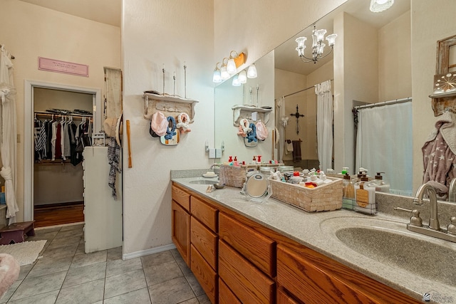 bathroom with tile patterned flooring, vanity, walk in shower, and an inviting chandelier