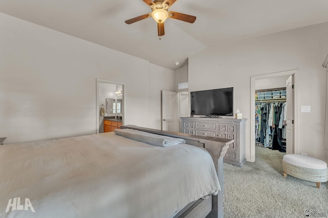 bedroom featuring a walk in closet, light carpet, a ceiling fan, a closet, and vaulted ceiling