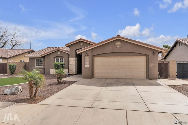 mediterranean / spanish-style house with stucco siding, fence, driveway, and a tile roof