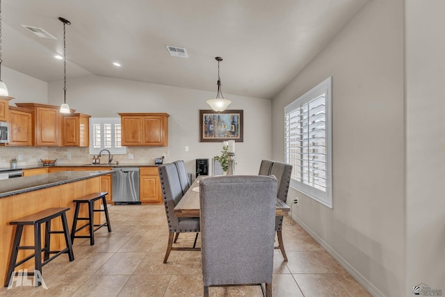 dining area with light tile patterned floors, visible vents, and vaulted ceiling