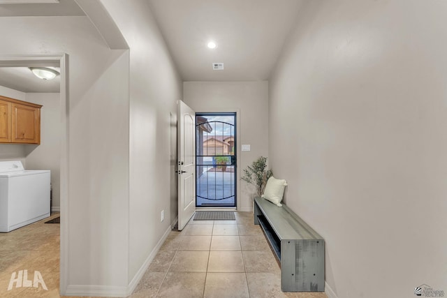 entryway with washer / dryer, light tile patterned floors, baseboards, and visible vents