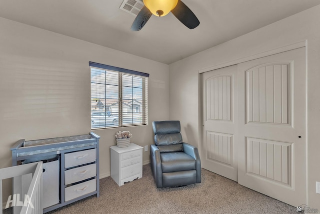 sitting room featuring visible vents, light colored carpet, and a ceiling fan