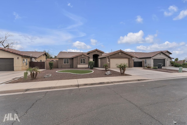 view of front of house with fence, a tiled roof, concrete driveway, stucco siding, and a garage