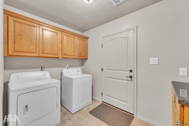 laundry area with cabinet space, baseboards, and washer and clothes dryer