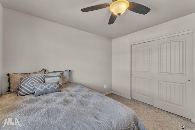 carpeted bedroom with a closet, baseboards, and a ceiling fan