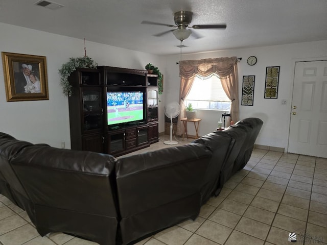 living room featuring ceiling fan, light tile patterned floors, and a textured ceiling