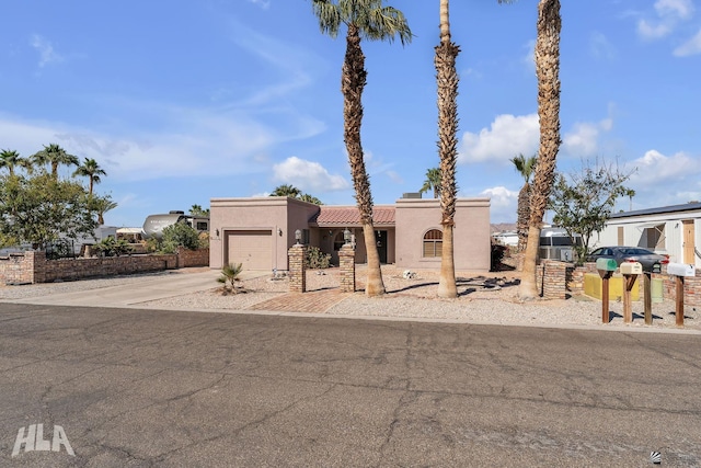 view of front facade featuring driveway, a tiled roof, an attached garage, and stucco siding