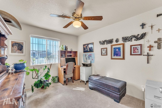 home office featuring ceiling fan, carpet floors, and a textured ceiling