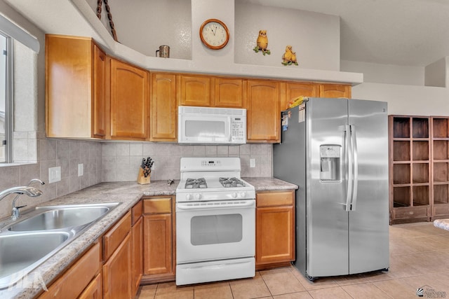 kitchen with tasteful backsplash, white appliances, light tile patterned flooring, and sink