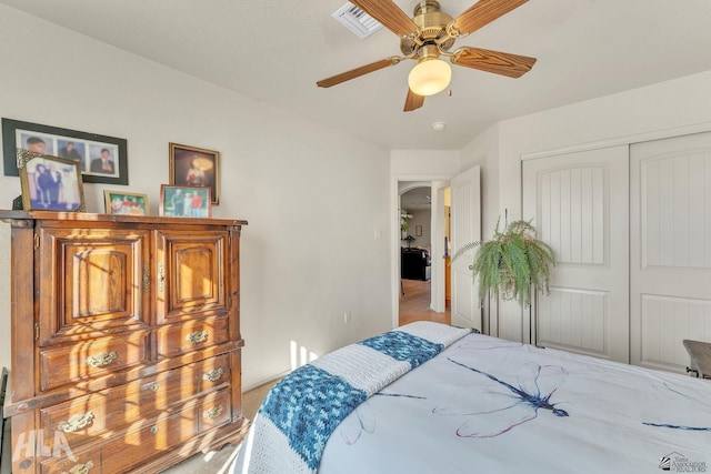 carpeted bedroom with ceiling fan and a closet