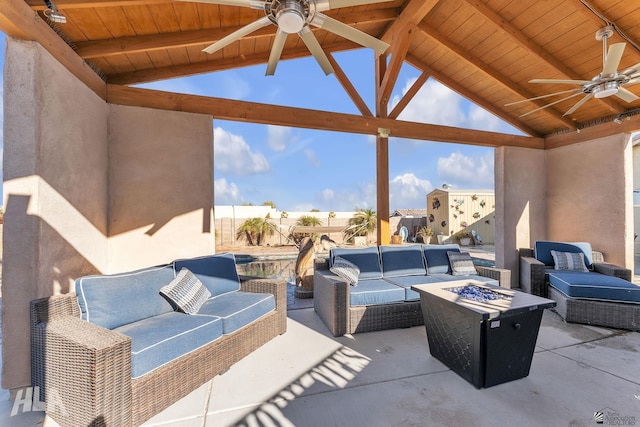 view of patio with ceiling fan and an outdoor living space with a fire pit