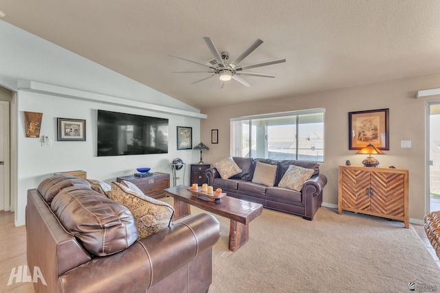 carpeted living room featuring lofted ceiling, a textured ceiling, and ceiling fan