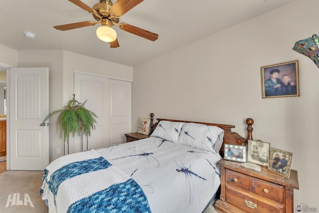 carpeted bedroom with ceiling fan and a closet