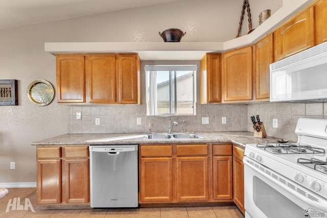 kitchen with lofted ceiling, sink, tasteful backsplash, light tile patterned floors, and white appliances