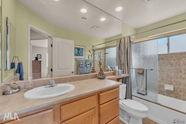 full bathroom with tile patterned flooring, bath / shower combo with glass door, vanity, and toilet