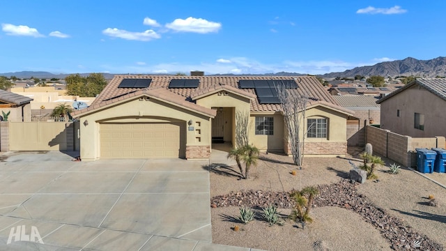 view of front of home featuring a mountain view, a garage, and solar panels