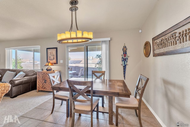 carpeted dining room featuring a chandelier