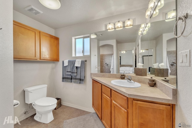 bathroom with tile patterned flooring, vanity, a shower, and toilet