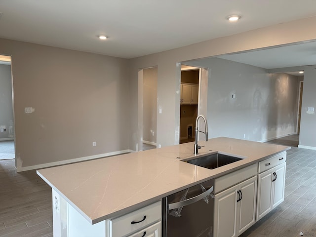 kitchen with white cabinetry, a sink, dishwasher, and wood finished floors