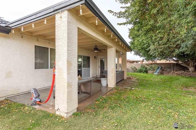 view of property exterior featuring a yard and ceiling fan