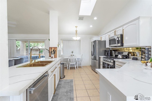 kitchen featuring pendant lighting, sink, light tile patterned floors, appliances with stainless steel finishes, and white cabinets