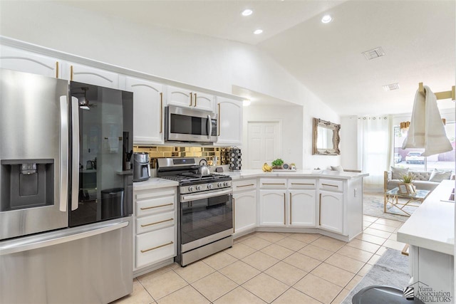 kitchen with lofted ceiling, light tile patterned floors, stainless steel appliances, tasteful backsplash, and white cabinets