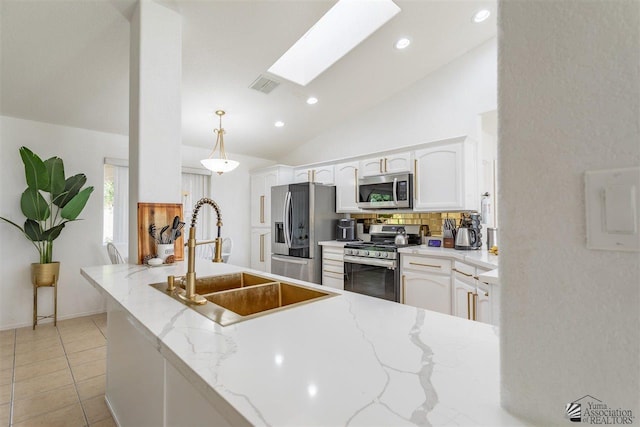 kitchen with sink, white cabinetry, decorative light fixtures, stainless steel appliances, and light stone countertops