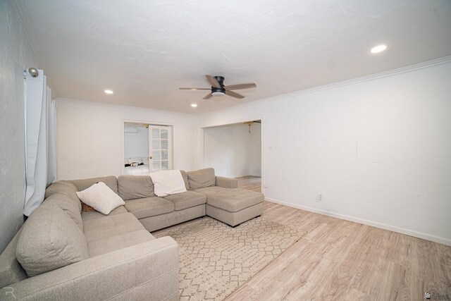 living room featuring light hardwood / wood-style floors, ceiling fan, and ornamental molding