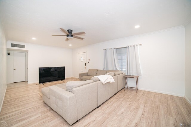 living room featuring ceiling fan, ornamental molding, and light wood-type flooring