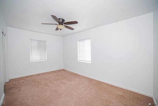 carpeted spare room featuring ceiling fan