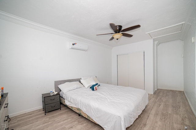 bedroom with ceiling fan, a wall mounted AC, light hardwood / wood-style floors, a closet, and ornamental molding