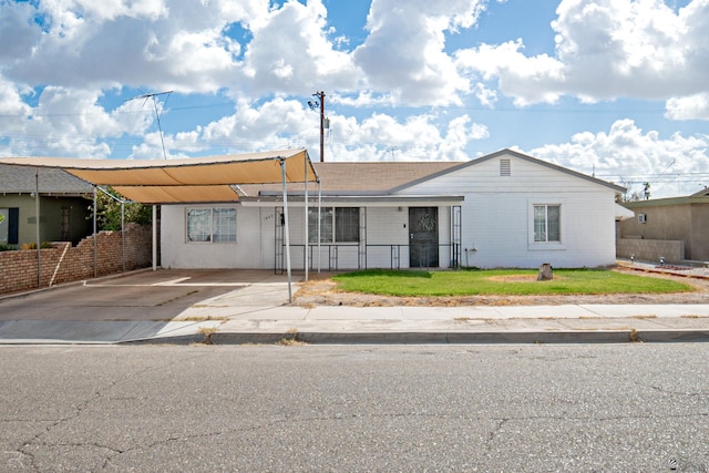 view of front of property with a front lawn and a carport