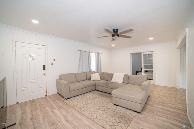 living room featuring ceiling fan, light hardwood / wood-style floors, and crown molding