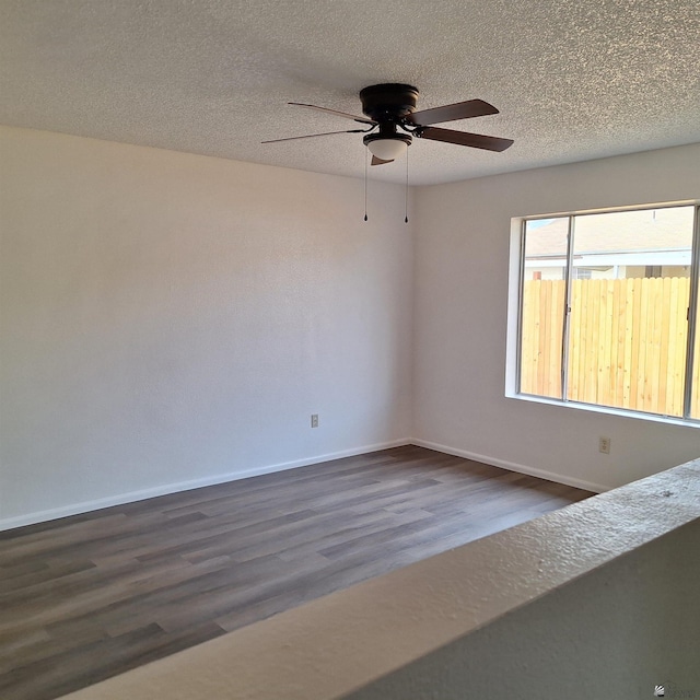 unfurnished room featuring dark wood-type flooring, ceiling fan, and a textured ceiling