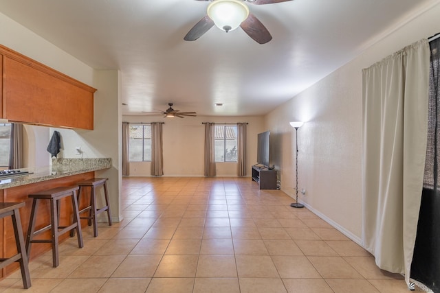 interior space with light tile patterned flooring and ceiling fan